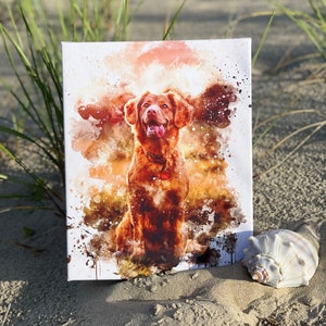 May include: A canvas print featuring a watercolor painting of a brown dog with its tongue out. The artwork has a white background with orange and brown paint splatters. A seashell rests on the sand next to the canvas.