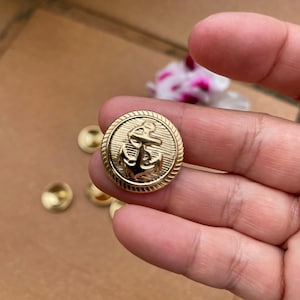 Pack of gold metal buttons with a nautical-style foot engraved with an anchor, 23 mm, ideal for jackets, parkas, coats, and military nautical fashion.