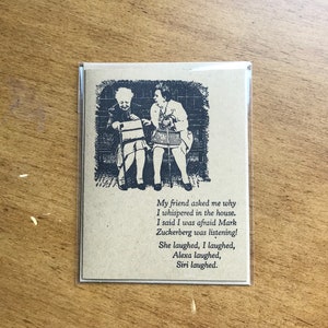 May include: A humorous card with a black and white illustration of two women sitting on a bench. The text on the card reads: "My friend asked me why I whispered in the house. I said I was afraid Mark Zuckerberg was listening! She laughed, I laughed, Alexa laughed, Siri laughed."
