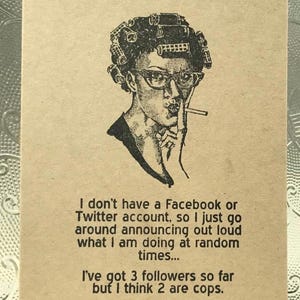 May include: A rectangular tan card featuring a black ink illustration of a person wearing hair rollers and glasses while holding a cigarette. The text reads: I don't have a Facebook or Twitter account, so I just go around announcing out loud what I am doing at random times... I've got 3 followers so far but I think 2 are cops.