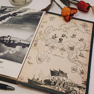 May include: A vintage map illustration featuring soldiers and a world map. A decorative jar with a wooden lid and bee pattern is in the background. The map is bound with metal rings and has a dark green border.
