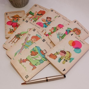 May include: A set of vintage game cards featuring colorful illustrations of people performing various activities. The cards are numbered 4 through 19 and include titles like "Life Guard Louic", "Phoning Flo", "Barbel", "Pop-Out Pa", "Moon-Shot Martha", "Astro Arthur", "Doctor Donald", "Thermo", and "Tackling".