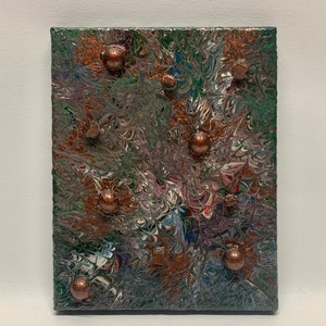 Puede incluir: Pintura abstracta sobre lienzo con un patrón de remolino verde, marrón y blanco. La pintura tiene una superficie texturizada con varios pequeños acentos redondos de color cobre.