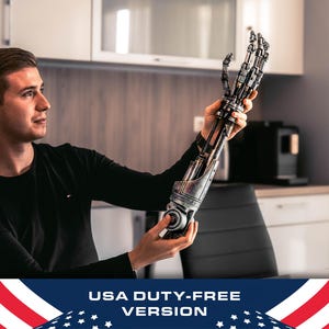 Könnte beinhalten: Ein detaillierter, metallischer Prothesenarm mit komplizierten mechanischen Komponenten. Der Arm wird hochgehalten und zeigt seine gegliederten Finger und den kolbenartigen Unterarm. Das Design weist Silber- und Dunkelgrautöne auf, was auf eine futuristische oder industrielle Ästhetik hindeutet.