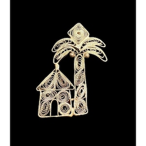 May include: A gold-colored wire sculpture of a house and palm tree. The sculpture is made of thin, coiled wire and has a delicate, intricate design.