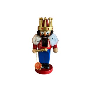 May include: A wooden nutcracker figurine of a king wearing a red and gold crown, a red and white robe, and blue pants. He is holding a golden scepter and has a white beard and mustache. The nutcracker is standing on a red base with a gold trim. The nutcracker has a label that says "Seiffen's Dresden" on it.