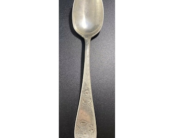 May include: A silver spoon with an ornate floral design on the handle.