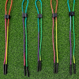 May include: Five colorful shoelace charms with black plastic tips. Each charm is a different color combination of rainbow colors.