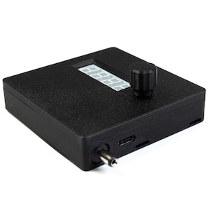 May include: A black electronic device with a digital display and a knob. The device has a USB port and a power jack.