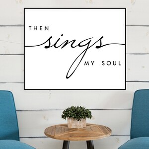 May include: A black and white print with the text "Then sings my soul" in a cursive font. The print is framed and hanging on a white wood wall.