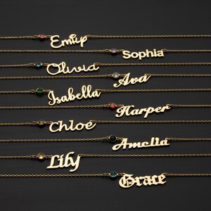 A collection of personalized name necklaces with gemstones, each featuring a different name engraved on it.