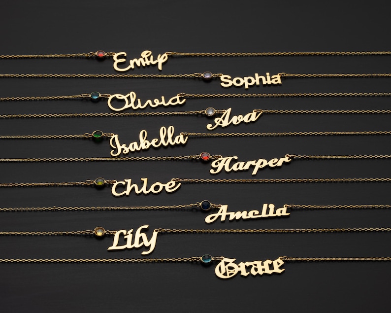 A collection of personalized name necklaces with gemstones, each featuring a different name engraved on it.