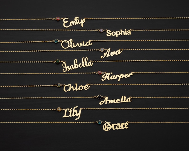 a collection of personalized name necklaces with gemstones, arranged in a row on a dark background.