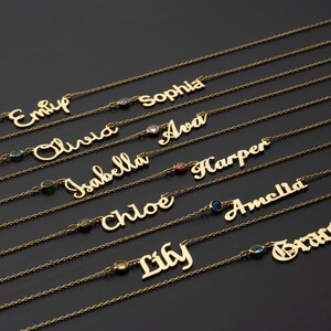 a collection of gold-colored necklaces with personalized names engraved on them, arranged in rows on a dark background.