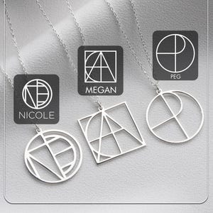 May include: Three silver geometric pendant necklaces with delicate chains. Each pendant features a unique design, with the names "NICOLE", "MEGAN", and "PEG" displayed on black square backgrounds. The pendants are displayed on a light gray surface.
