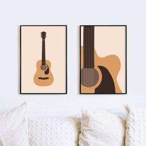 Peut inclure: Deux impressions encadrées d'une guitare acoustique brune. La première impression montre la guitare entière, tandis que la deuxième impression montre un gros plan du trou sonore et des cordes de la guitare.