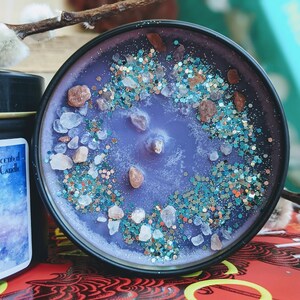 May include: Purple soy wax candle with a glittery, sparkly finish. The candle is topped with small pieces of pink and white rock salt. The candle is in a black tin with the text "Luxury Scented Soy Wax Candle" and "Salt" on the label.