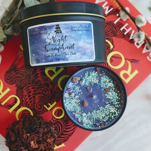May include: A black soy wax candle with a gold lid. The label reads "Handpoured in NC Naturally Sourced" and "Luxury Scented Soy Wax Candle". The candle is labeled "Night Triumphant" with the scent notes "Rain | Citrus | Sea Salt" and is 8 oz.