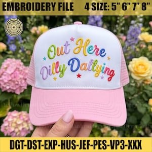 以下が含まれることがあります： カラフルな文字で「Out Here Dilly Dallying」と刺繍されたピンクと白のトラッカーハット。帽子はピンクのつばとメッシュの背面を備えています。刺繍ファイルは4つのサイズで利用できます：12.7cm、15.2cm、17.8cm、20.3cm。