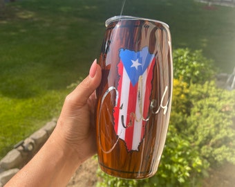 Puede incluir: Un vaso marrón y blanco con un diseño de veta de madera. El vaso presenta un gráfico de la bandera puertorriqueña y la palabra "Culebra" escrita en cursiva.