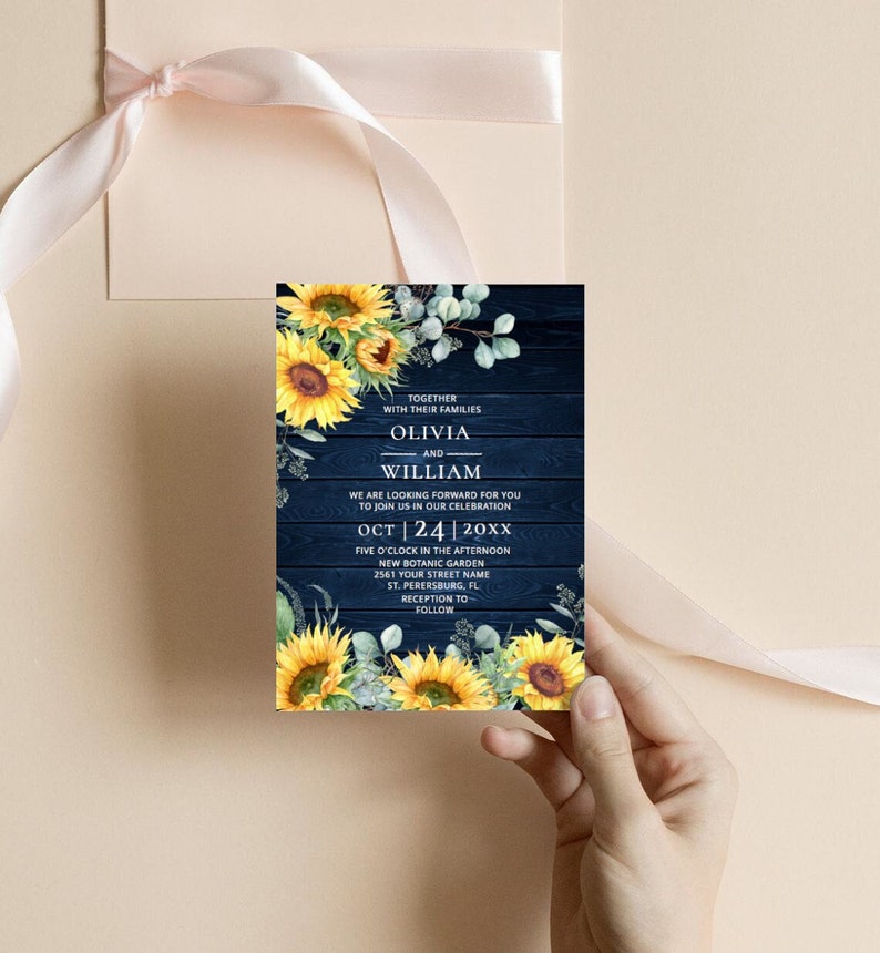 May include: A wedding invitation with a navy blue wood grain background, adorned with yellow sunflowers and green foliage. The invitation includes the names "Olivia and William" and event details.