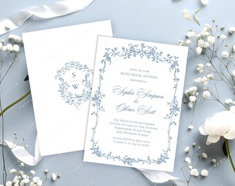 Op de afbeelding: Witte trouwkaart met blauwe bloemenrand en tekst. De uitnodiging bevat de namen "Sophie Simpson & Oliver Scott" en evenementdetails. Een bijpassende envelop met een bloemenmonogram is ook zichtbaar.