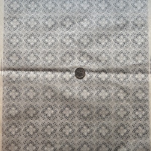 Puede incluir: Una imagen en blanco y negro de un patrón repetitivo de nudos entrelazados. El patrón es simétrico y crea una sensación de movimiento.