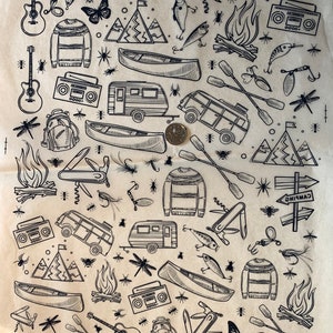 May include: A black and white illustration pattern on brown paper featuring camping and outdoor activities. The pattern includes a camper van, a canoe, a campfire, a guitar, a backpack, a fishing lure, a dragonfly, a butterfly, a mountain range, a sign that says "Camping", and a sweater.
