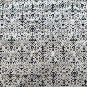 May include: White fabric with a repeating pattern of black skulls, hearts, flowers, and stars. The pattern is a traditional Mexican design.