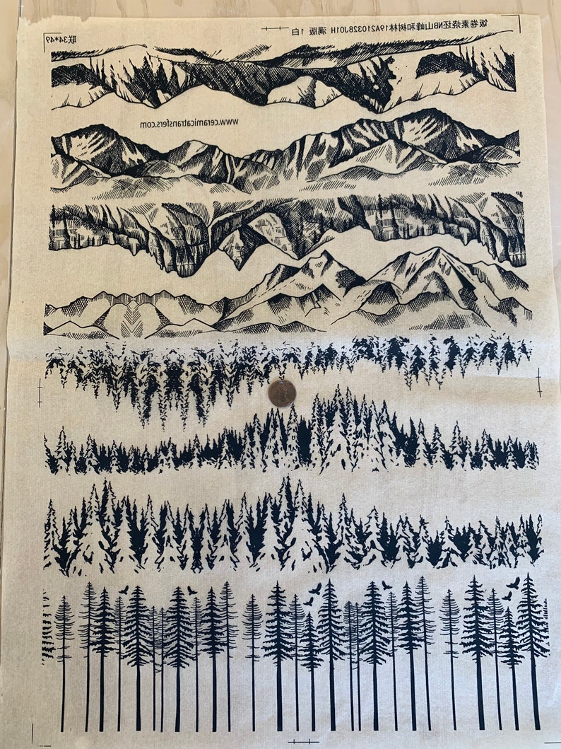 May include: A sheet of black and white transfer designs for crafting. The designs include various mountain ranges and forest scenes. The sheet is labelled "Ceramic Transfers" and includes the website "www.ceramictransfers.com".