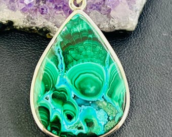 May include: A teardrop-shaped pendant with a green malachite stone set in sterling silver.
