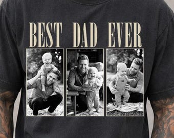 May include: A charcoal gray short-sleeve t-shirt featuring the text BEST DAD EVER in a beige serif font above three rectangular black and white photographic panels showing a parent and child in various poses together.
