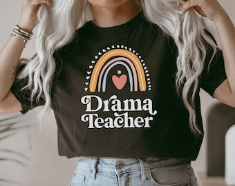 May include: A black t-shirt with a rainbow and heart design and the text "Drama Teacher" in white.