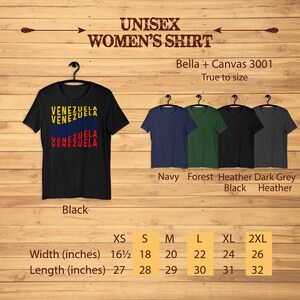 May include: Black unisex t-shirt with the word "VENEZUELA" in yellow, blue, and red. The shirt is displayed on a wooden background with other t-shirt colors: navy, forest green, black, and dark heather grey. Sizes range from XS to 2XL.