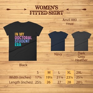 May include: A fitted black t-shirt with the text "In My Doctoral Student Era" in colorful letters. The shirt is available in sizes S, M, L, XL, and 2XL. The shirt is also available in navy and dark grey heather.