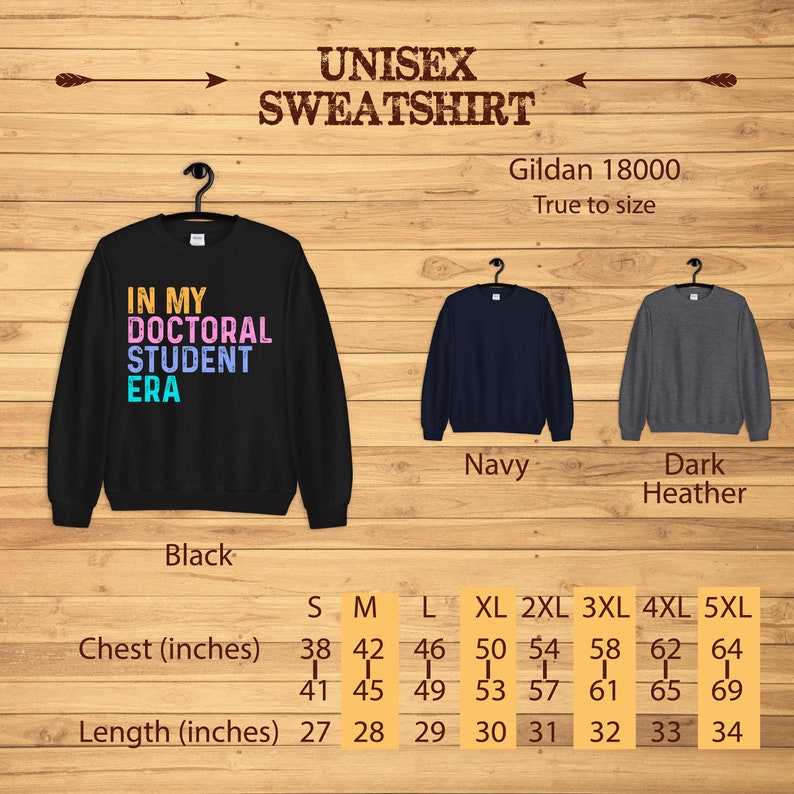 May include: Black, navy, and dark heather unisex sweatshirt with the text "In My Doctoral Student Era" in rainbow colors. Size chart with chest and length measurements in inches.