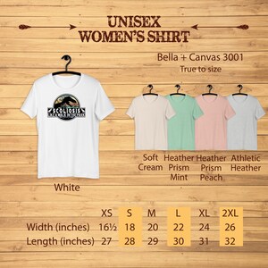 May include: White unisex t-shirt with a graphic of a dinosaur with the text "Scoliosis Like A Walk In The Park". The shirt is available in sizes XS to 2XL. The size chart shows the width and length of the shirt in inches.