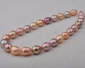 May include: A strand of baroque pearls in shades of pink, peach, and lavender. The pearls are strung on a white cord and are of varying sizes and shapes.
