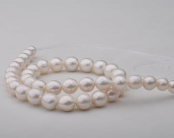 May include: A strand of white freshwater pearls, strung on a white thread. The pearls are round and smooth, with a slightly irregular shape.