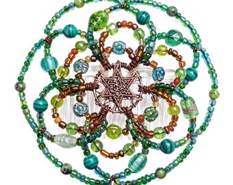 May include: A green and brown beaded hair comb with a copper star design in the center. The comb is made of plastic and has a decorative design.