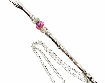 May include: A silver-toned metal wand with a decorative handle, adorned with a pink and crystal bead. A matching silver chain with a star-shaped pendant is attached. The wand is designed with intricate details.