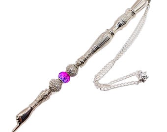 May include: A silver-toned pointer with a chain and a star-shaped charm. The pointer has a hand-shaped handle and is decorated with pink and clear rhinestone beads.