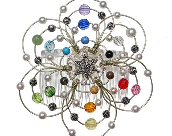 May include: A silver hair comb with a star-shaped charm in the center. The comb is decorated with a variety of colorful beads, including green, blue, red, and orange.