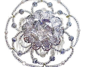 May include: A silver hair comb with a large, ornate flower design and a circle of white beads.
