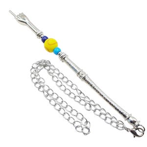 May include: A silver chain with a silver pendant featuring a raised middle finger and a yellow softball with blue and turquoise beads.