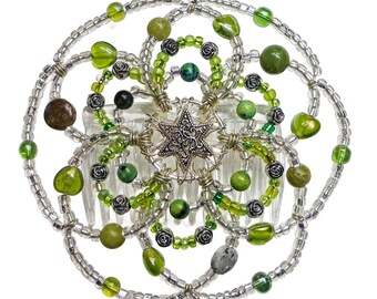 May include: A silver and green beaded hair comb with a star-shaped charm in the center. The comb is decorated with small green beads and larger green stones.
