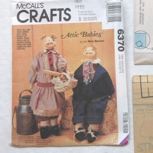 May include: A vintage sewing pattern for making two pig dolls. The pattern is titled "Attic Babies" and is from McCall's Crafts. The pattern number is 6370.