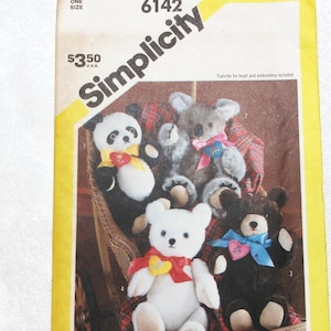 May include: A Simplicity 6142 sewing pattern envelope featuring a photograph of four plush bears: a panda, a koala, a white bear, and a black bear. Each bear wears a colorful ribbon with a heart-shaped accent. The yellow and white paper envelope displays the brand name Simplicity and the pattern number 6142.