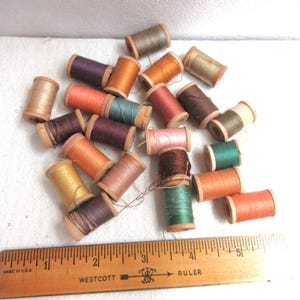 Vintage wood spools of thread, all with varying amounts of thread, mostly cotton. Lot of 23 spools from different makers, different eras.