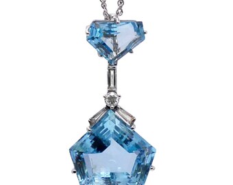 May include: A delicate pendant necklace featuring two aquamarine gemstones, one larger and one smaller, set in a silver or white gold setting. The larger aquamarine is a hexagonal shape with a faceted cut, while the smaller aquamarine is a square shape with a faceted cut. The necklace is accented with small diamonds.